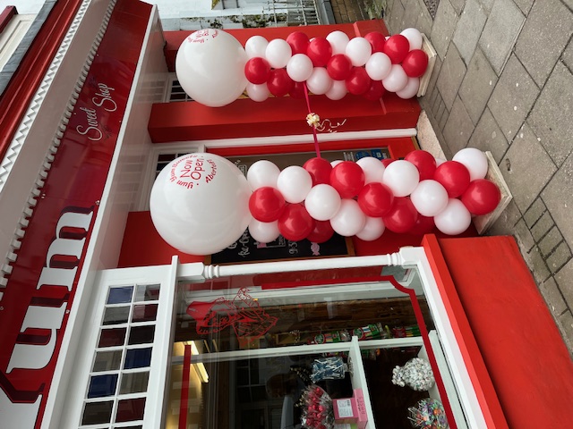 Red and white balloon columns outside a shop