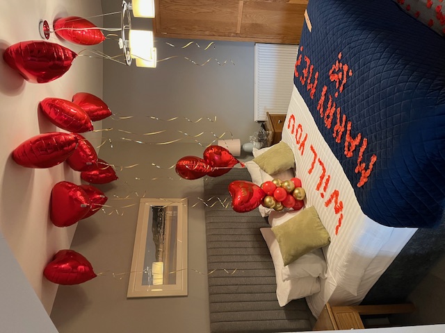Red heart balloons decorating a bedroom for an anniversary