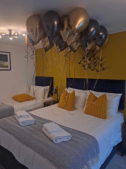 Gold, black and bronze balloons arranged in a bedroom