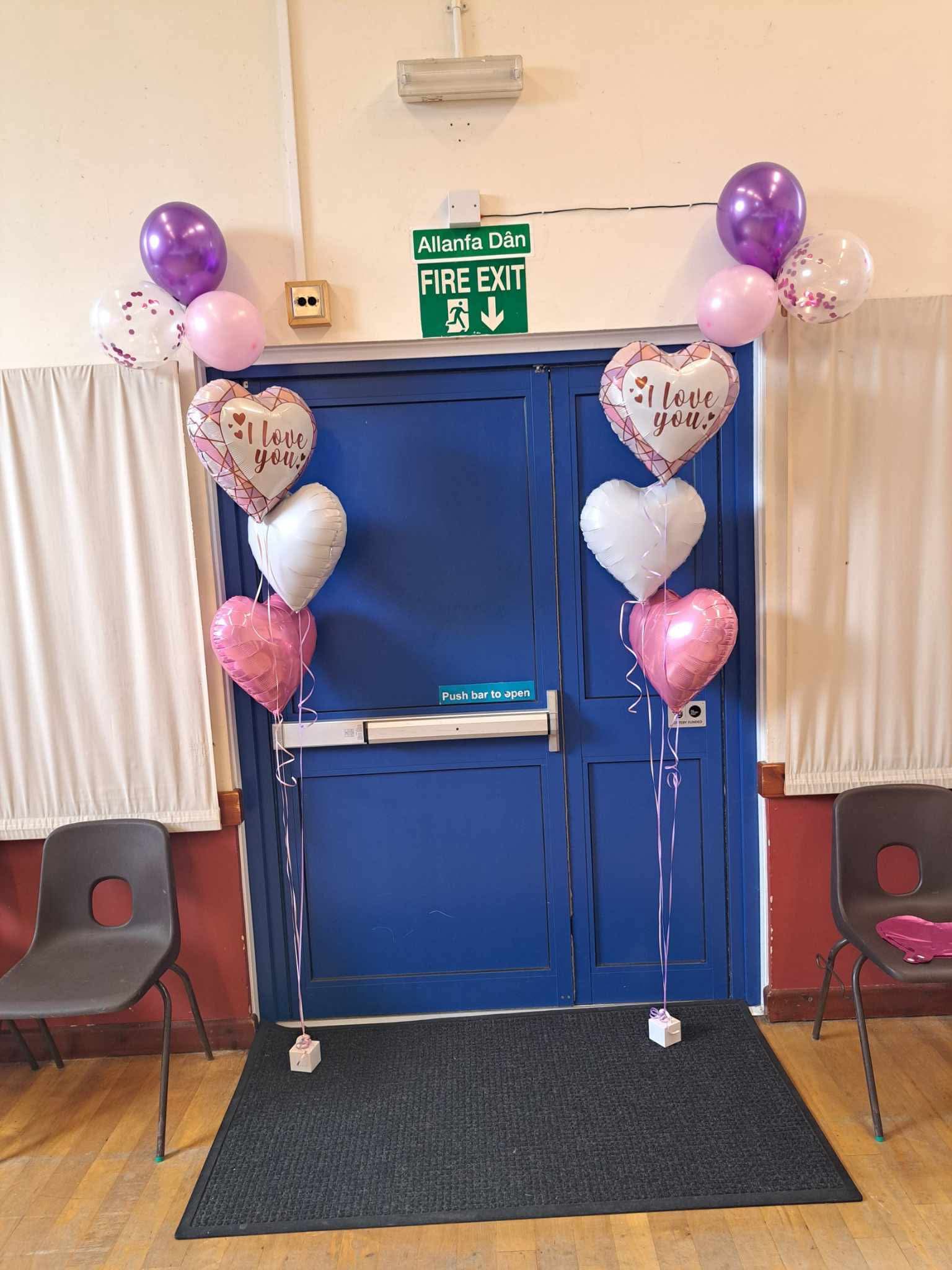 Purple and pink balloons framing a display board