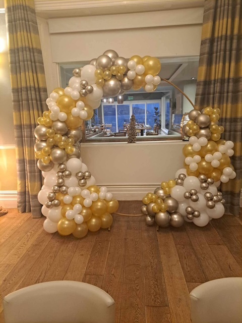 White and gold balloon arch and towers indoors